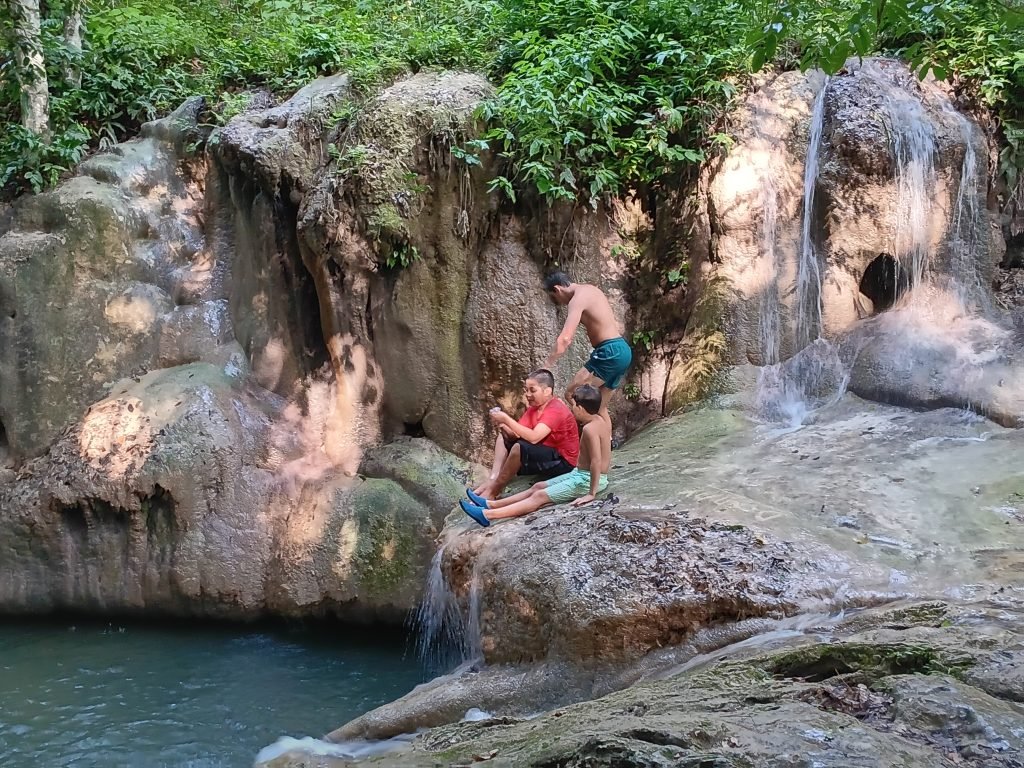 Guests relaxing at Monkey Falls swimming hole near The Cabins at Monkey Falls