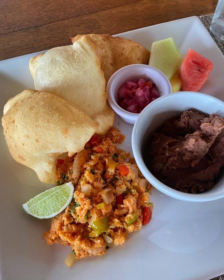 Belizean breakfast with fry jacks, eggs, beans, and lime